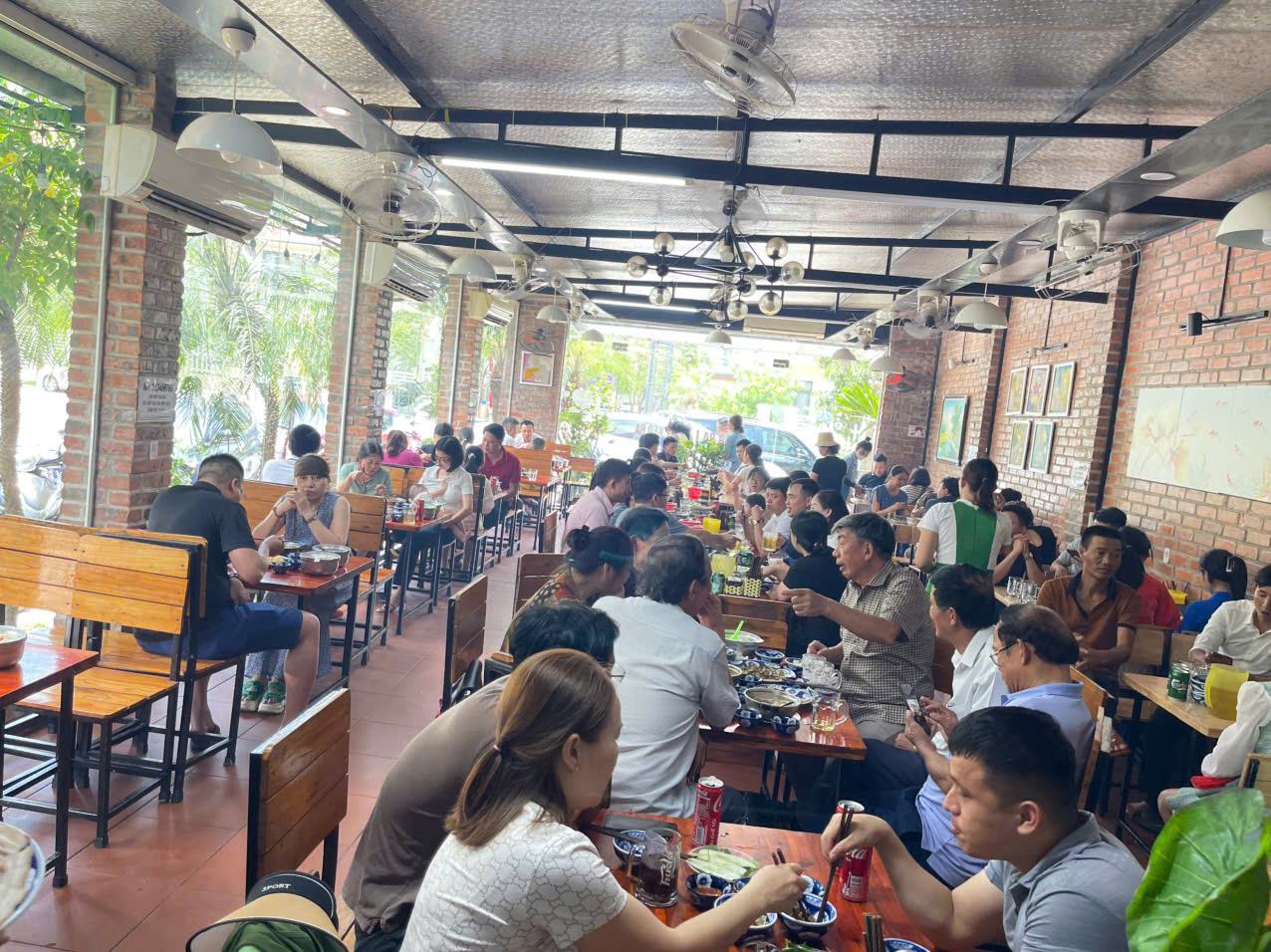 Khách xếp kín các dãy bàn gỗ trong quán